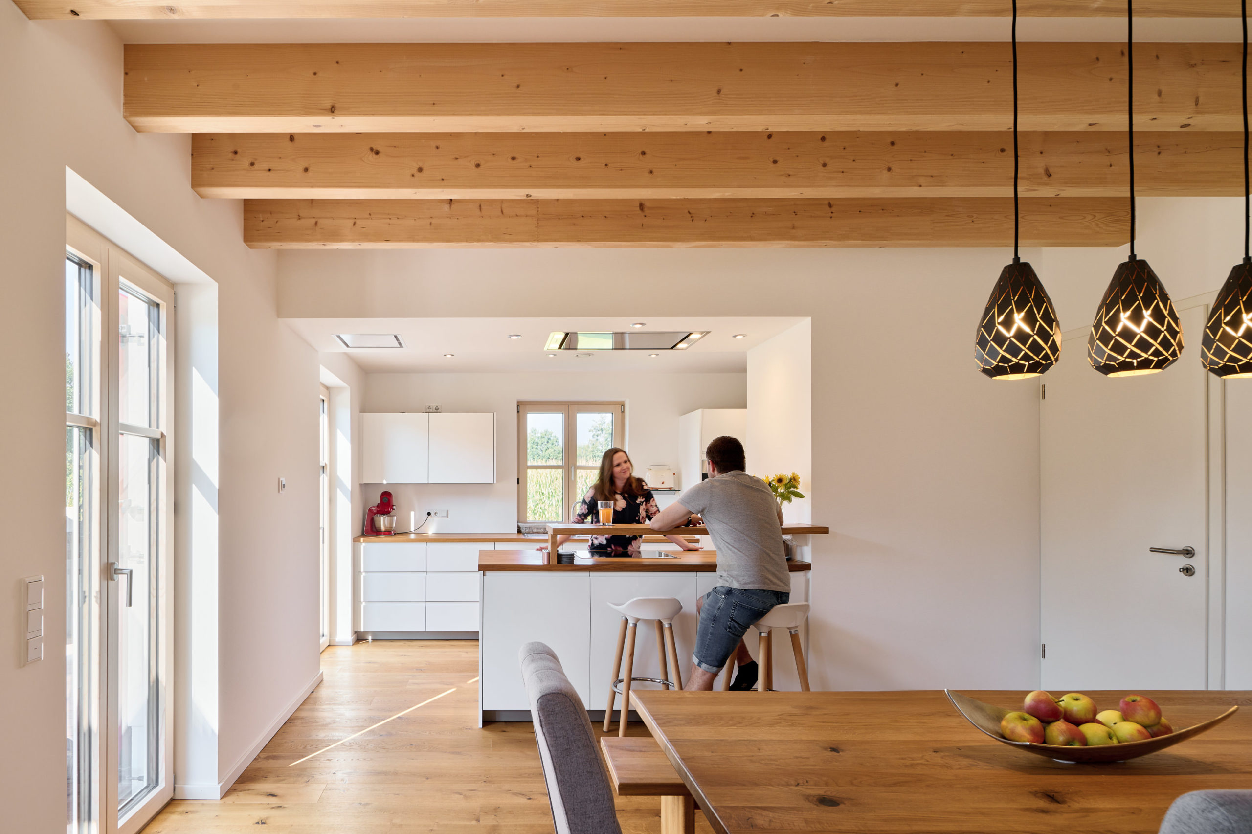 Küchen und Esszimmer eines fertigen Holzhauses von Donaubauer Holzbau mit sichtbarer Holzdecke