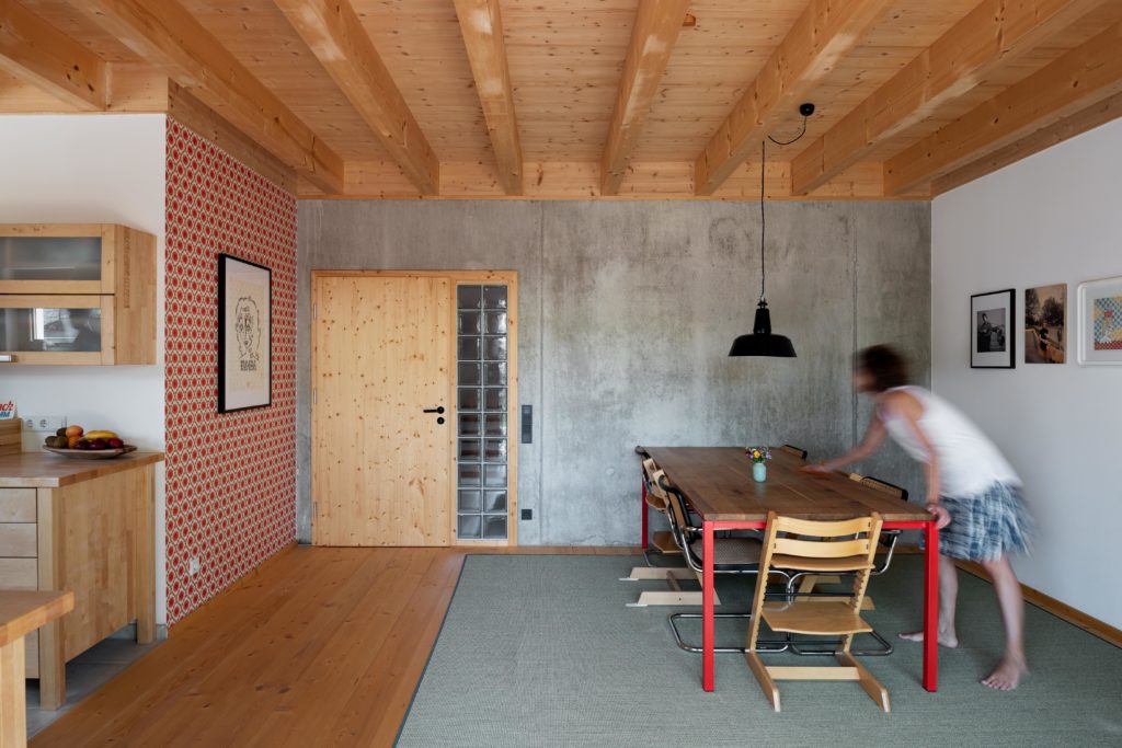 Materialmix im Esszimmer mit Holzdecke, Sichtbeton und Retrotapete